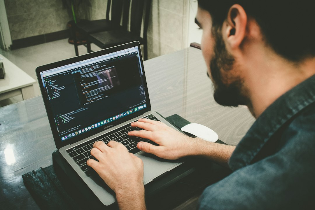 Software developer working at a laptop, representing long-running AI-assisted coding sessions