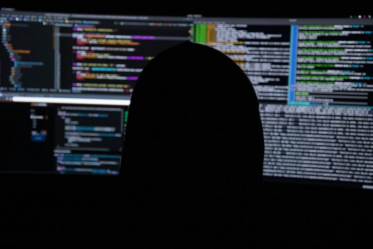 Cybersecurity analyst at multiple monitors illustrating Anthropic's September 2026 AI threat intelligence report
