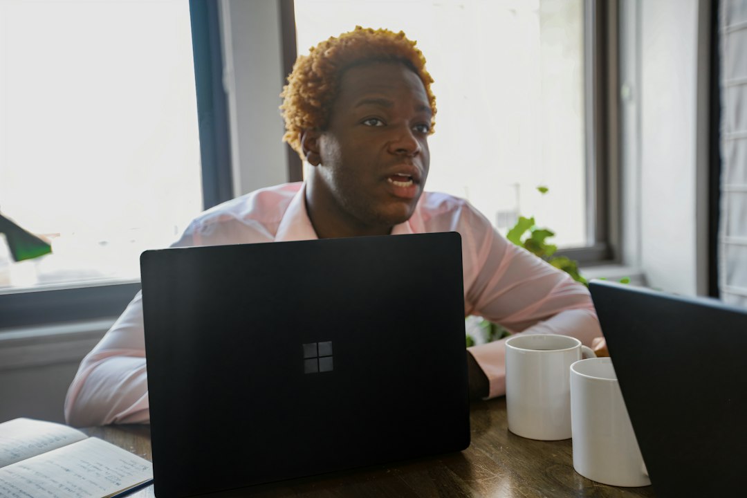 Professional using a Microsoft Surface laptop, illustrating AI-assisted spreadsheet work through the Copilot side pane
