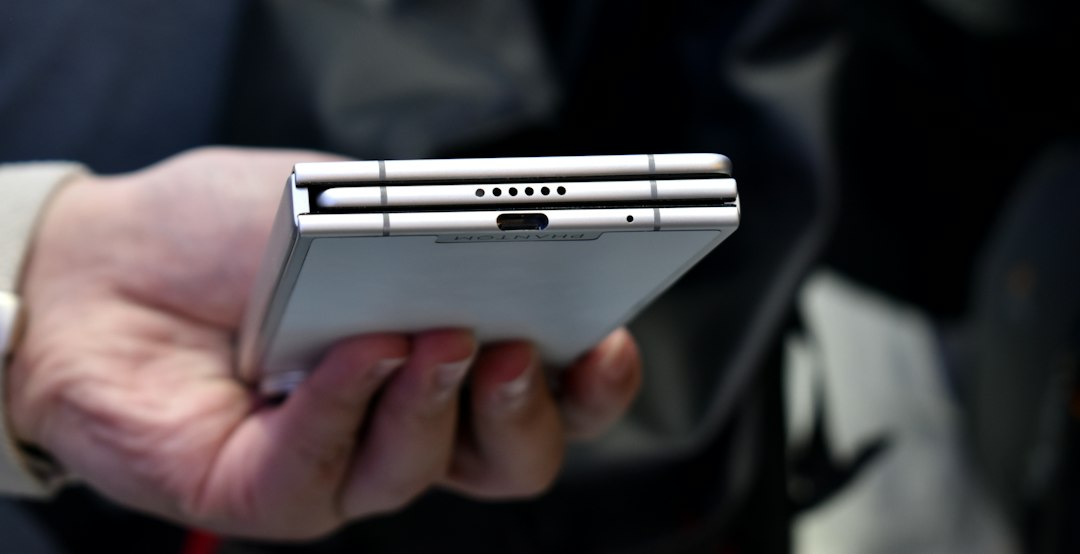 Person holding a foldable smartphone, illustrating case fit and edge gesture compatibility for foldable phones
