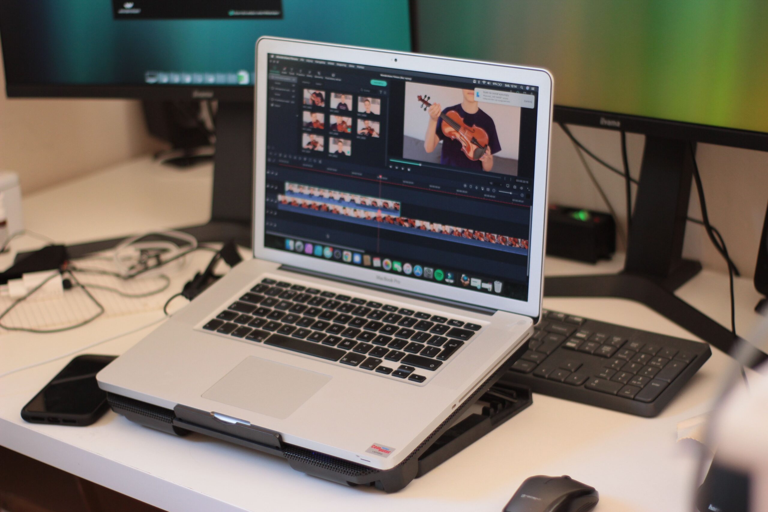 Laptop showing video editing software on a creator workspace