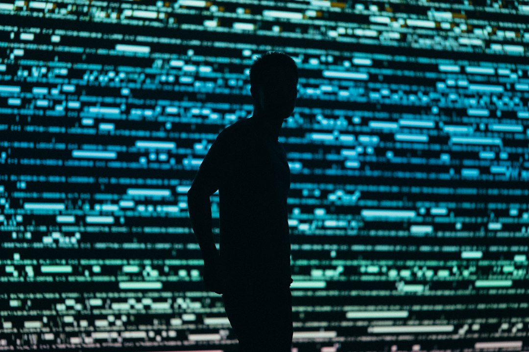 Silhouetted person at a computer illustrating threat actors using AI for malicious activity
