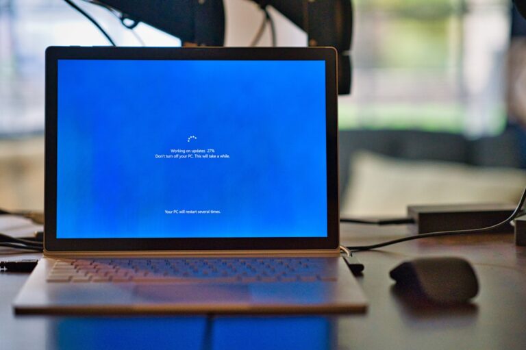 Microsoft Surface laptop installing a Windows update, illustrating Windows 11 KB5129195 emergency update