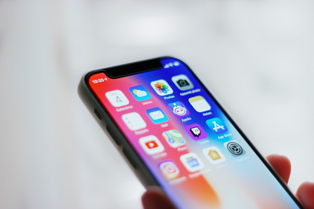 Person holding an iPhone while reviewing privacy and battery settings after an iOS 27 update