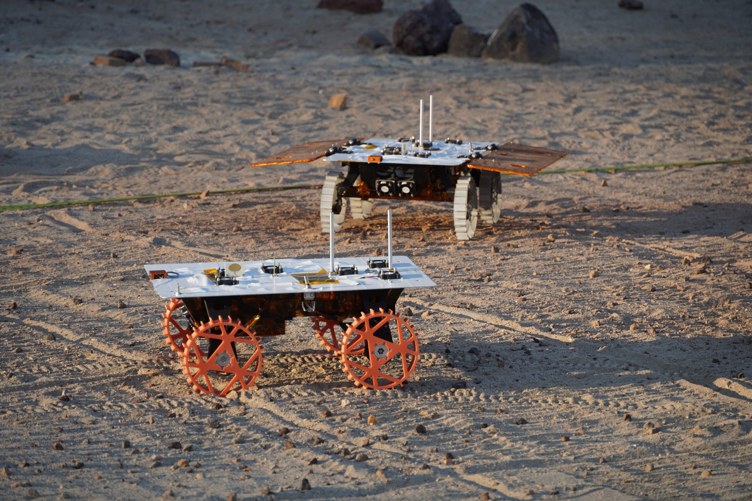 Two NASA CADRE autonomous rover prototypes driving together in JPL’s Mars Yard