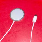 Original photograph showing a MagSafe wireless charging puck and USB-C cable for iPhone, not a charging repair test
