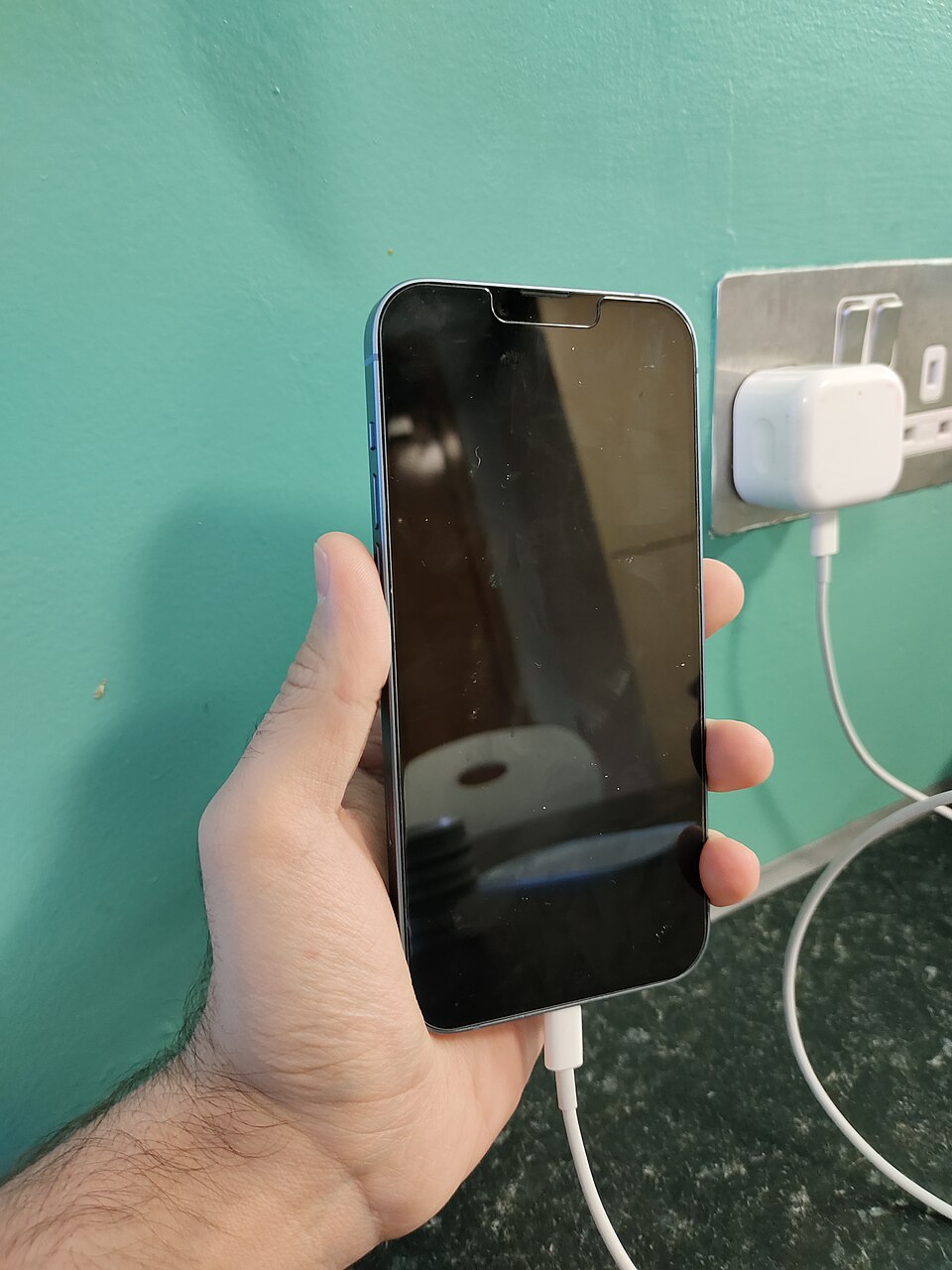 Real iPhone 14 Plus plugged into a cable, photographed by Kskhh; an illustration of charging rather than a failed charging test