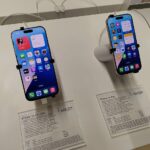 Original real-world photograph of iPhone 16 Pro and iPhone 16 Pro Max, illustrating an iPhone settings guide; not a cache-clearing screenshot