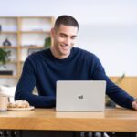 Person using a Surface Laptop associated with Microsoft's Windows 11 2026 Update announcement